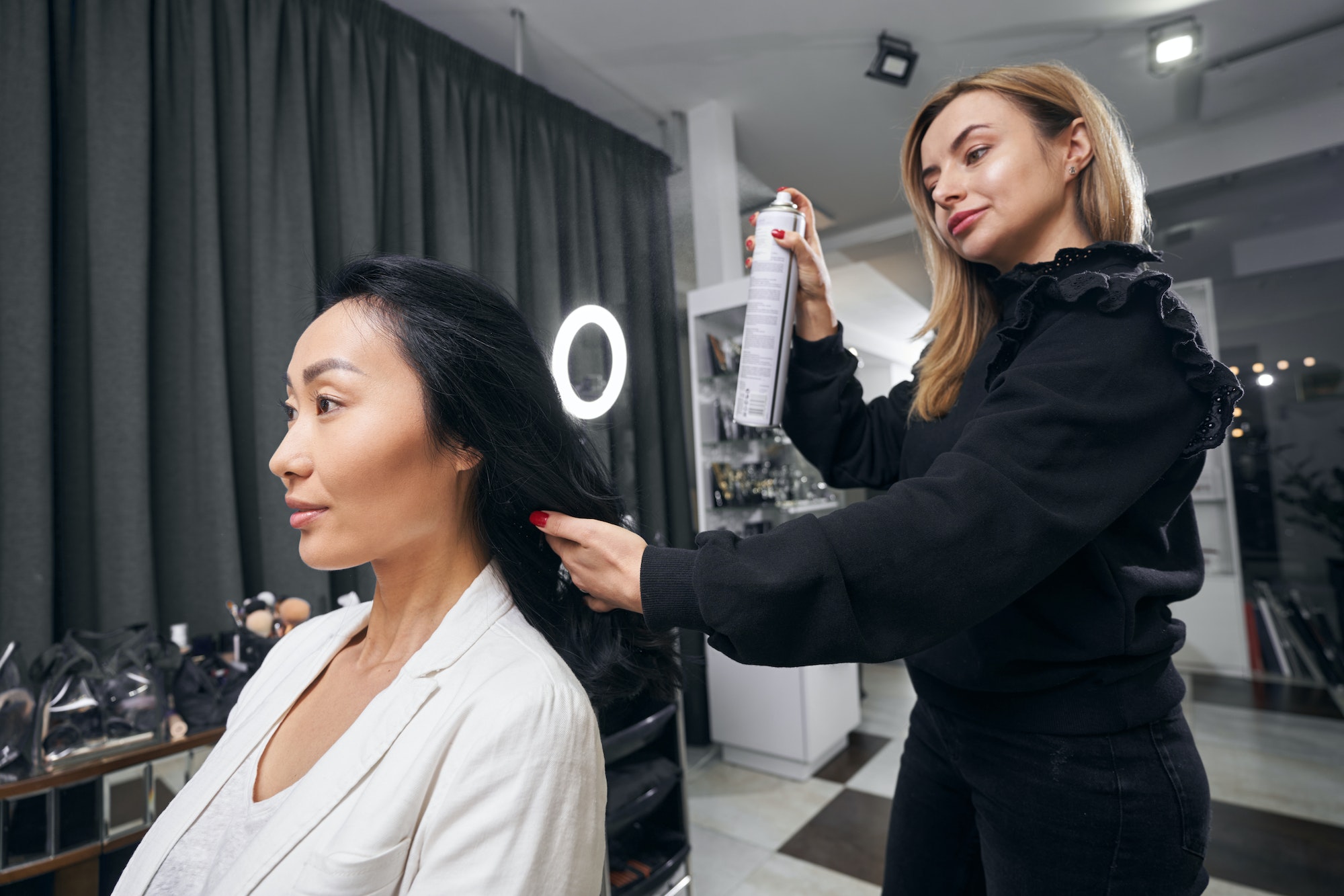 Attractive Asian female receiving professional hair care in the barber shop
